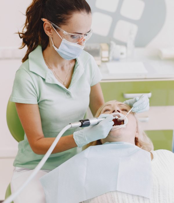 Senior woman having dental treatment at dentist's office. Woman is being treated for teeth