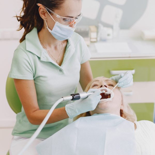 Senior woman having dental treatment at dentist's office. Woman is being treated for teeth